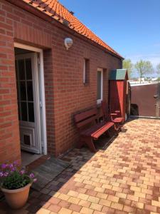 un edificio in mattoni con panchina su un patio di Ferienwohnung am Binnensee a Heiligenhafen