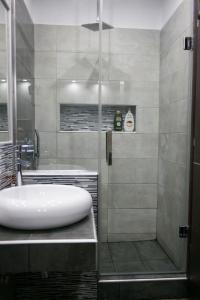 a bathroom with a shower with a white sink at Zen Luxury Living in Thessaloniki