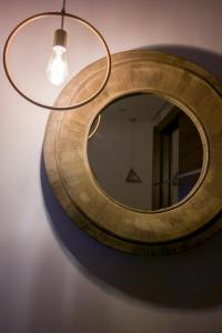 uno specchio circolare appeso a un soffitto con una luce di Zen Luxury Living a Salonicco