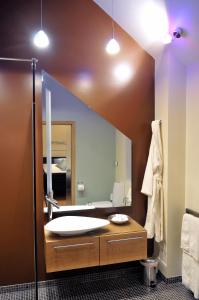 a bathroom with a sink and a large mirror at South Lodge in Milton Keynes