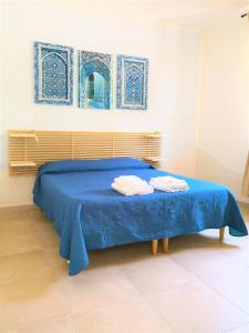 a blue bed with two towels on top of it at B&B Dimora Mariù in Taranto