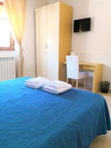 a bedroom with a blue bed with a chair and a desk at B&B Dimora Mariù in Taranto