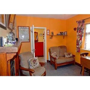 a living room with two chairs and a red refrigerator at Hannah's Cottage in Farranfore