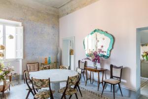 a dining room with a table and chairs and a mirror at Casa Iris Bed and Breakfast in Orbetello