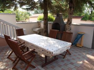 a table and chairs on a patio with a grill at Villa Zelmira in Peroj