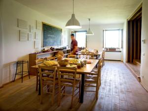 a kitchen and dining room with a table and chairs at Ostello Bello Assisi Bevagna in Bevagna