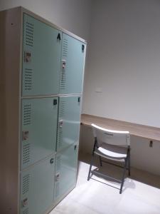 a chair sits in front of a room with lockers at KLA B&B in Kaohsiung