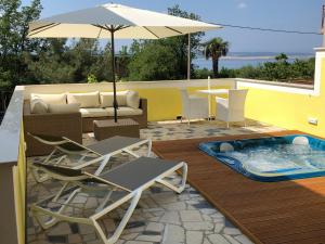 a patio with chairs and an umbrella and a pool at Apartments & Rooms Marina in Dramalj