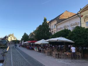 a group of people sitting at tables under umbrellas at DH Duomo III apartment in Košice