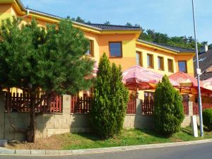 a yellow building with trees in front of it at Hotel Pohádka in Most