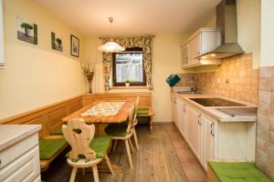 a kitchen with a wooden table and chairs at Apartma Pr Gatej in Bohinj