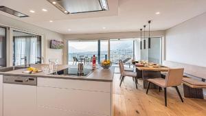 uma cozinha e sala de jantar com mesa e cadeiras em Penthouse Skygarden em Scena