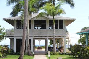 a house with palm trees in front of it at Hotel Villas Las Palmas al Mar in Las Terrenas