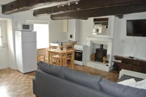 sala de estar con sofá azul y cocina en Caurel Cottage en Caurel