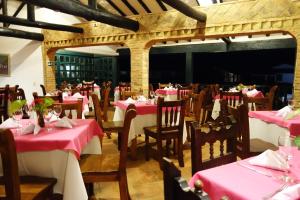 a restaurant with red and white tables and chairs at Hotel Andres Venero in Villa de Leyva +38 photos