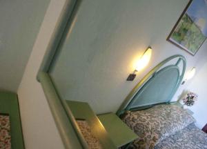 a bedroom with a bed with a headboard and a table at Hotel Danila in Portoferraio