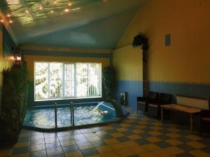 a swimming pool in a room with a window at Дом для Души с бассейном in Vinnytsya