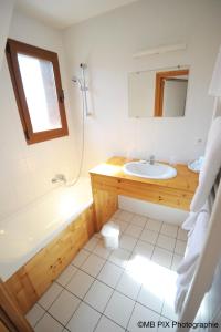 La salle de bains est pourvue d'un lavabo, d'une baignoire et d'un miroir. dans l'établissement Auberge d'Anthy, à Anthy