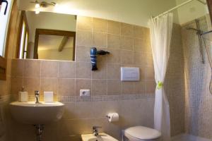 un bagno con lavandino, water e specchio di La Casa Del Poeta a Aglientu