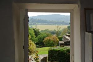 an open door to a view of a field from a garden at Caurel Cottage in Caurel