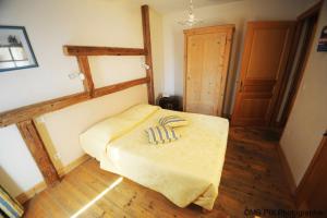 een slaapkamer met een bed met een gele deken bij Auberge d'Anthy in Anthy