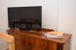TV de pantalla plana en la parte superior de un armario de madera en Apartment Monika en Kotor