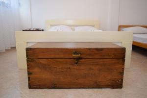 ein weißes Bett mit einer Holzkiste im Schlafzimmer in der Unterkunft Apartment Monika in Kotor