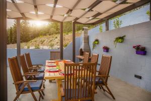 un patio avec une table et des chaises sous un toit dans l'établissement Villa Blue Hill, à Kaštela