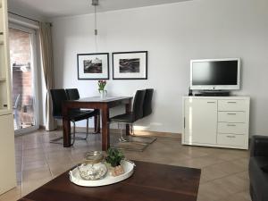 un salon avec une table et une télévision dans l'établissement Haus Roland Wohnung 33, à Zinnowitz