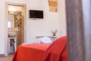 Habitación con cama con mantel rojo en Il Cortile dei Nonni, en Morciano di Leuca