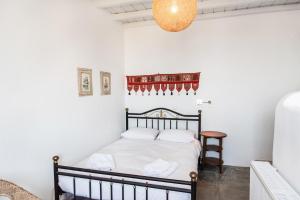 een slaapkamer met een bed in een kamer met witte muren bij Villa Tina in Arnados