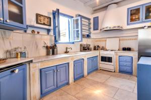 a kitchen with blue cabinets and white appliances at Villa Tina in Arnados