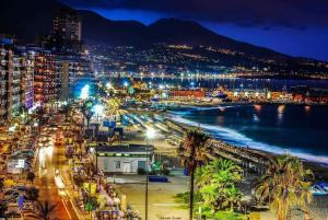 a view of a city at night with a beach at Holiday wanda in Fuengirola