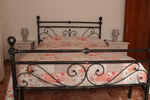 1 dormitorio con cama de metal y colcha con motivos florales en Luisa Appartamento Lunigiana in Cinque Terre, en Ceparana