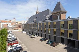 a large building with cars parked in a parking lot at Residentie Alfa Inn*** in Blankenberge
