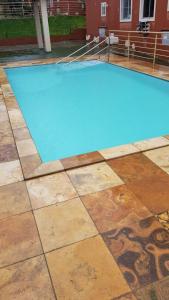 una piscina de agua azul en un suelo de baldosa en Apartamento em Natal/RN, en Natal