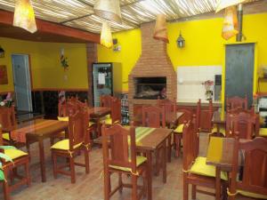un restaurante con paredes amarillas y mesas y sillas de madera en La Casa de Mia Mama en Salta