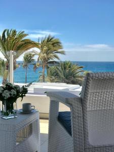 un patio con mesa, sillas y el océano en Apartamento Seaview, en Puerto del Carmen