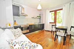 uma sala de estar com um sofá branco e uma cozinha em Grand Apartments Duet em Sopot