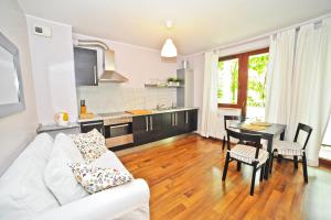 uma sala de estar com um sofá branco e uma mesa em Grand Apartments Duet em Sopot