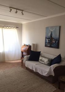 a living room with a couch and a window at SIMONSBERG in Simonʼs Town