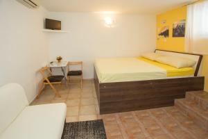 a small bedroom with a bed and a table at Room Dioklecijan in Split
