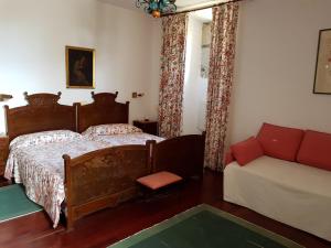 een slaapkamer met een bed en een bank bij Pazo Vilabade in Vilabade