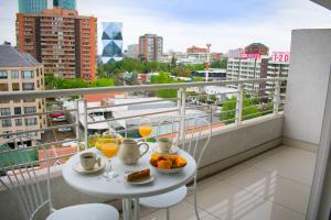 una mesa con comida y bebida en el balcón en Carmelitas Contemporary, en Santiago