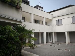 帕多瓦的住宿－Villa Zen Apartment，一座白色的大建筑,前面有一棵棕榈树