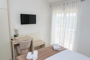 1 dormitorio con 1 cama, escritorio y TV en B&B Villa Ellena en Međugorje