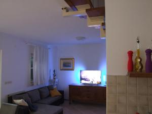 ein Wohnzimmer mit einem Sofa und einem TV in der Unterkunft Holiday Home Katia in Pučišća