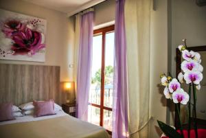 a bedroom with a bed and a window with flowers at Hotel Villa Fiorita in Sorrento