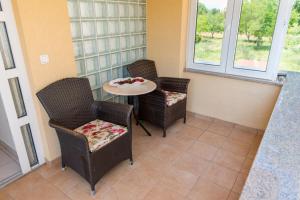 a room with two chairs and a table and a table and two windows at B&B Villa Ellena in Međugorje