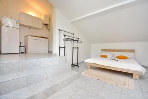 a white room with a bed and a refrigerator at Apartmani Maća in Sikovo